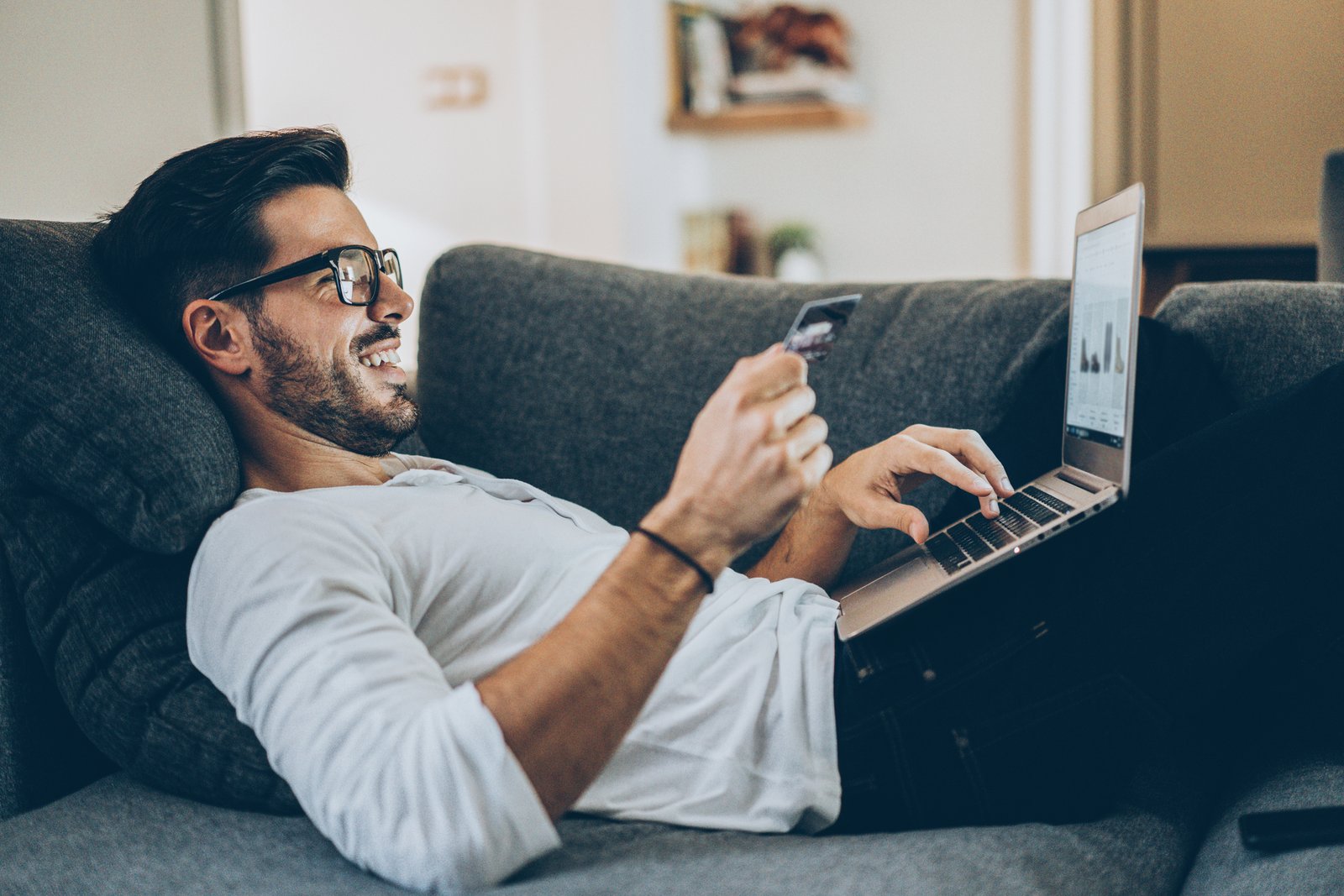 Man paying online with a card on his laptop