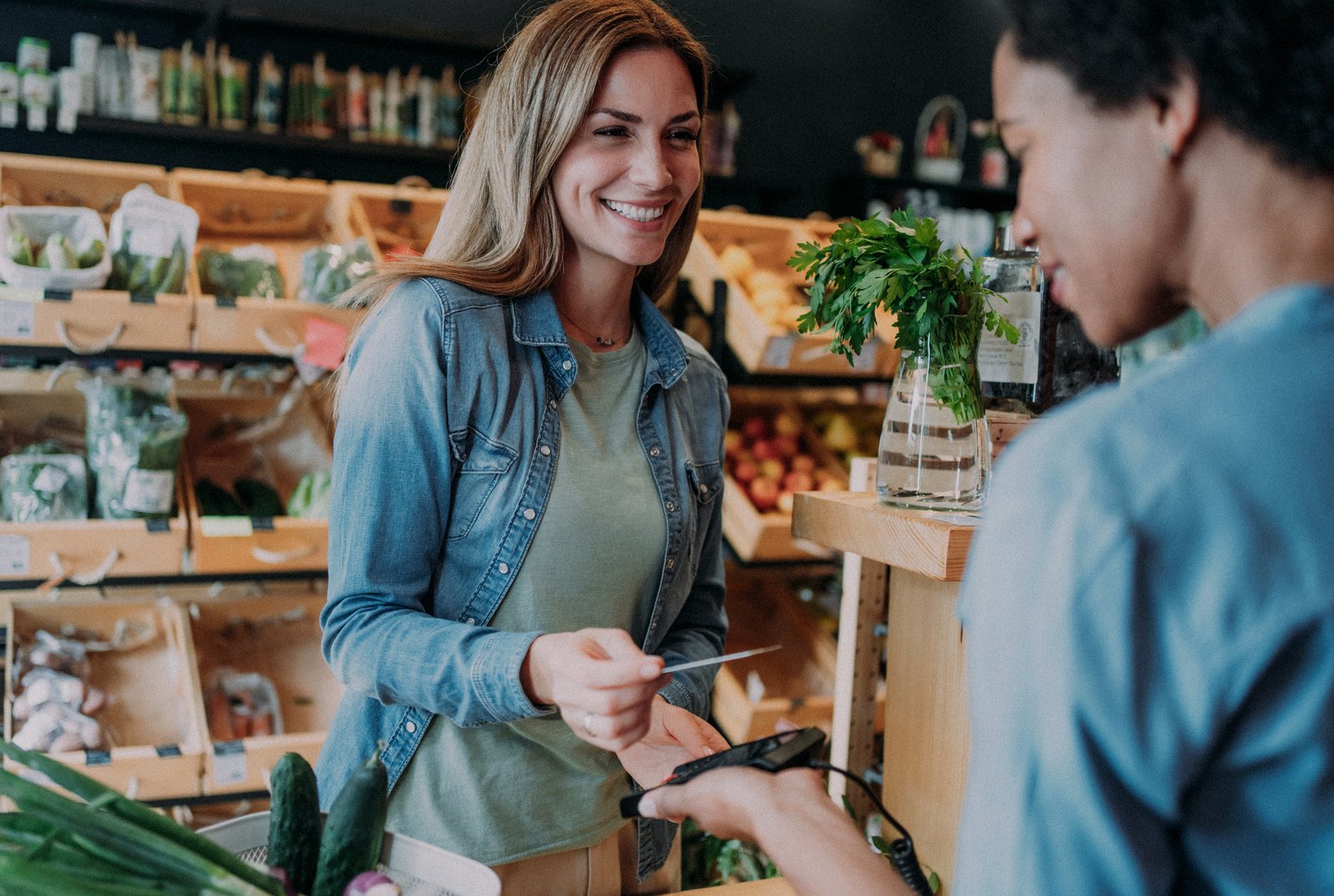 Shopper paying by card at a grocery checkout terminal